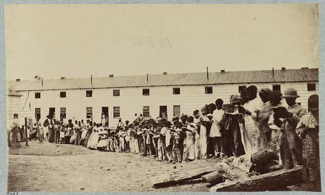 Freeman Village Arlington, VA. African Americans standing outside of an old building during the civil war