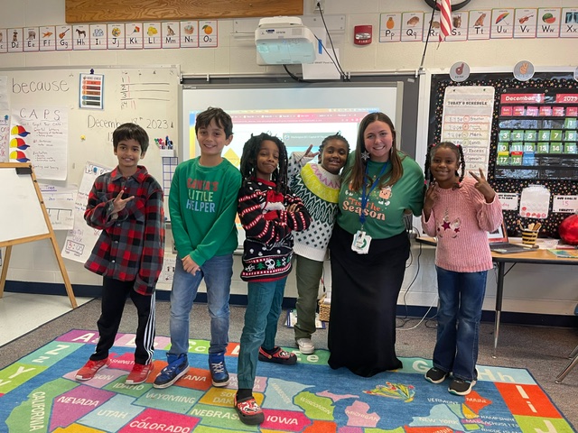 5 students and teachers wearing holiday sweater.