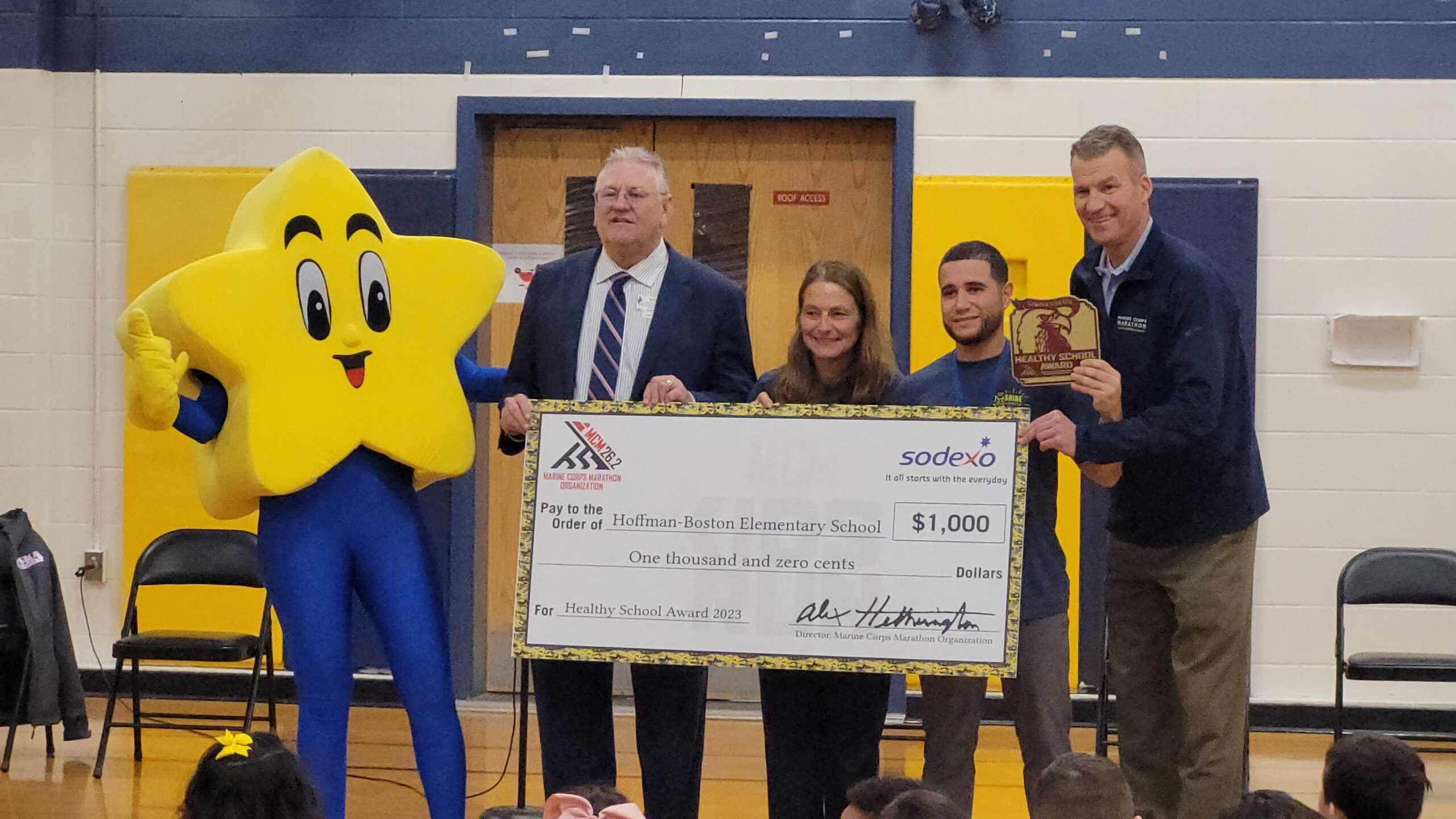 PE teachers and Twinkle receiving $1,000 check for Marine Corp Kids Fun Run