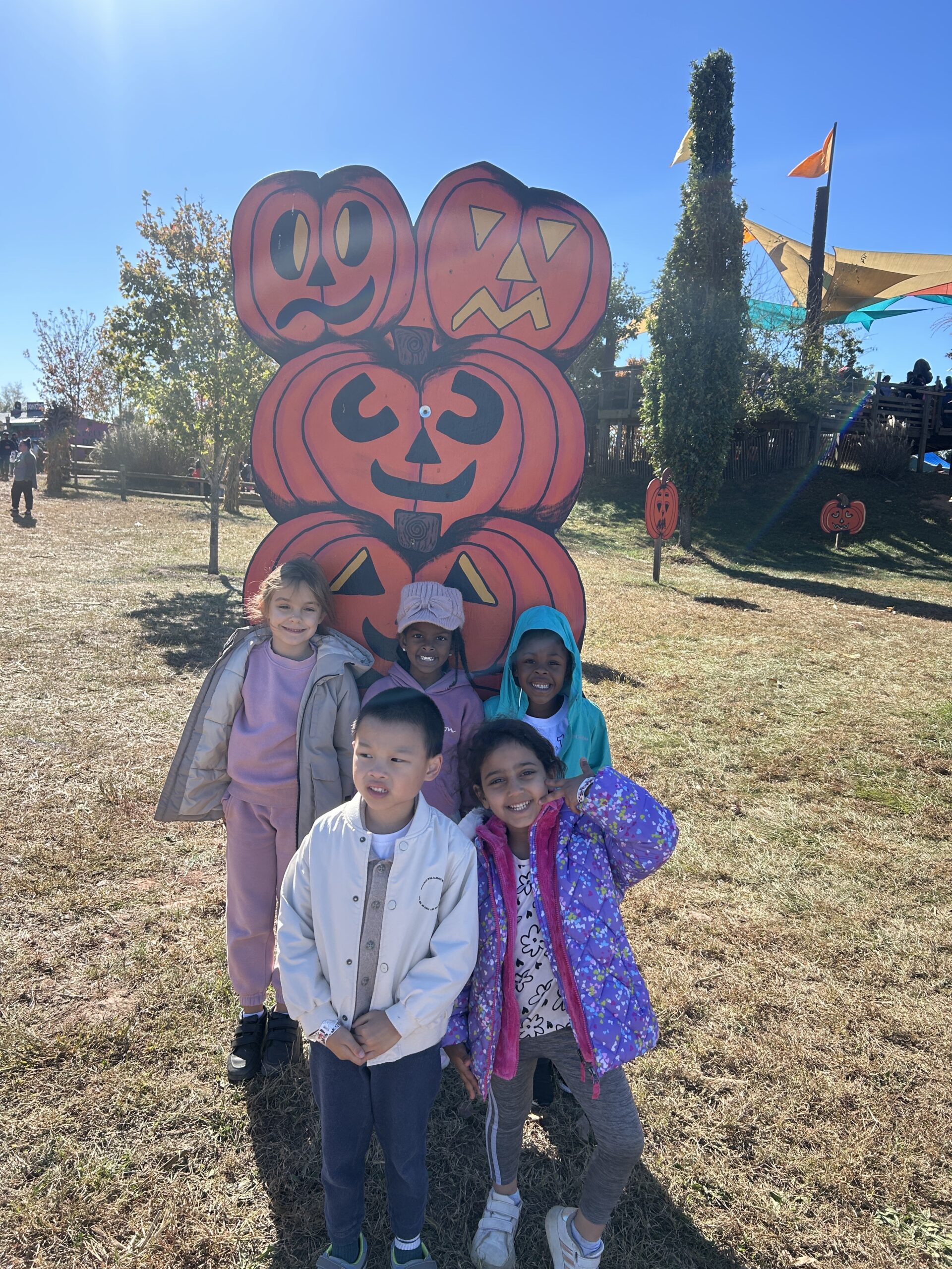 Students post in from of jacko lantern stature.