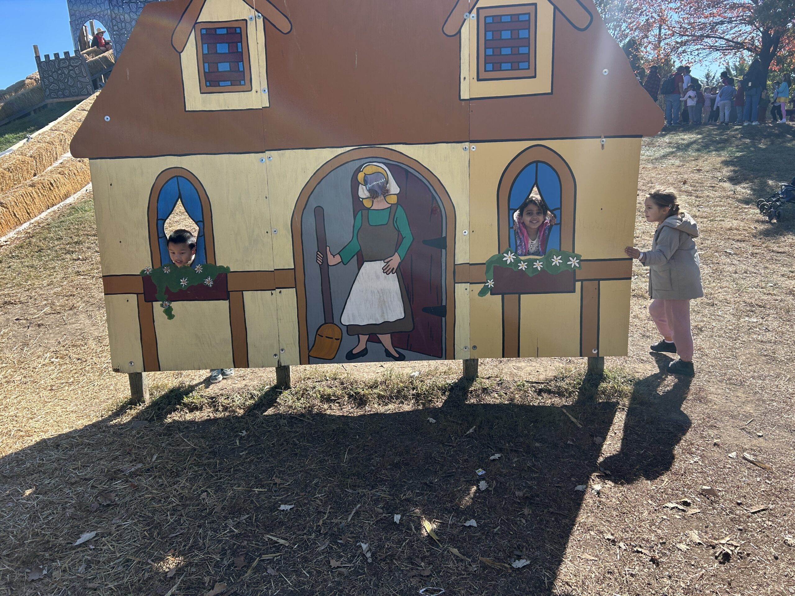 Students post in from of a farm house miniature