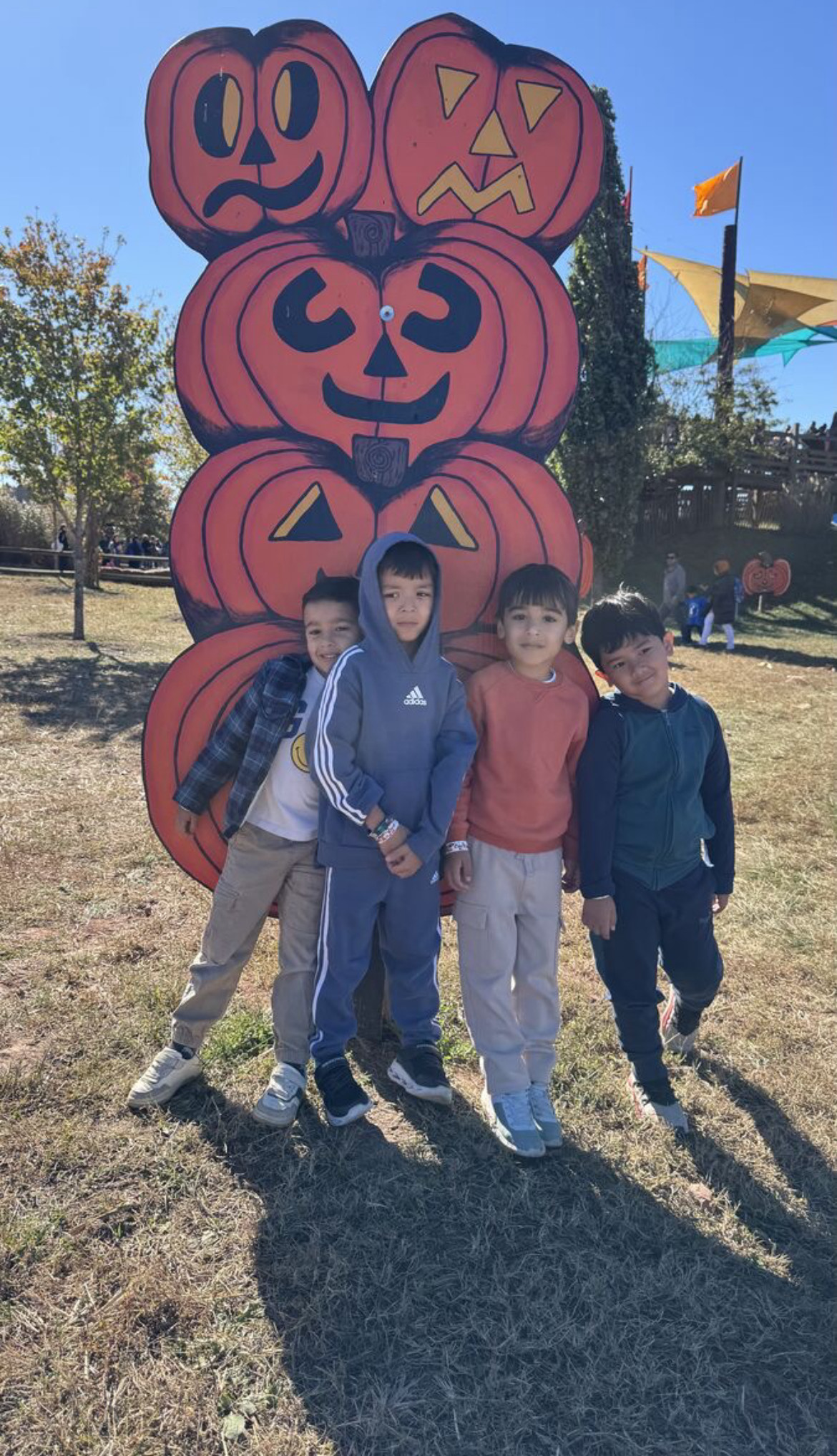 four students posting in front of jack o lantern stature