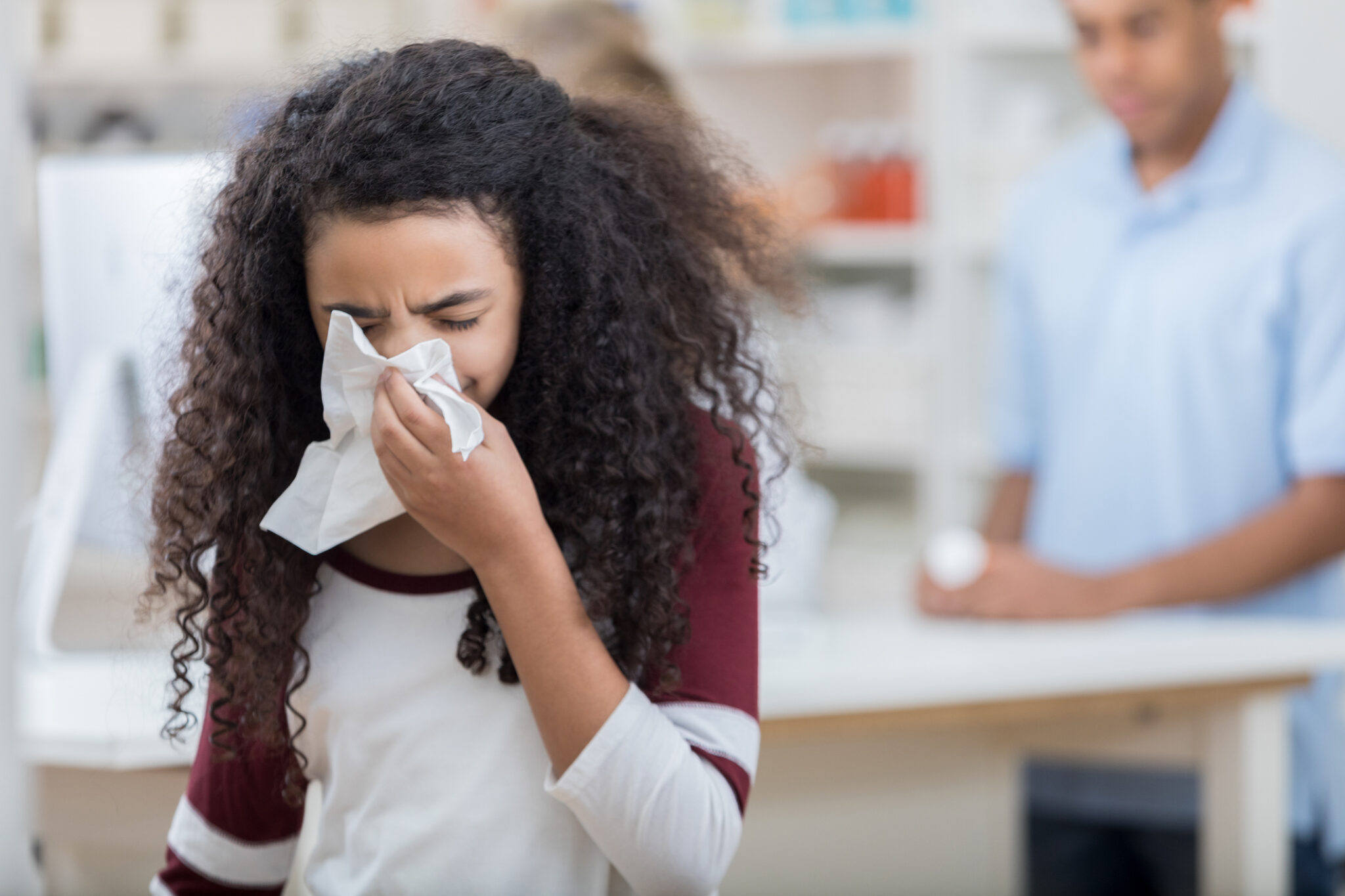 a person using tissue to wipe her nose.