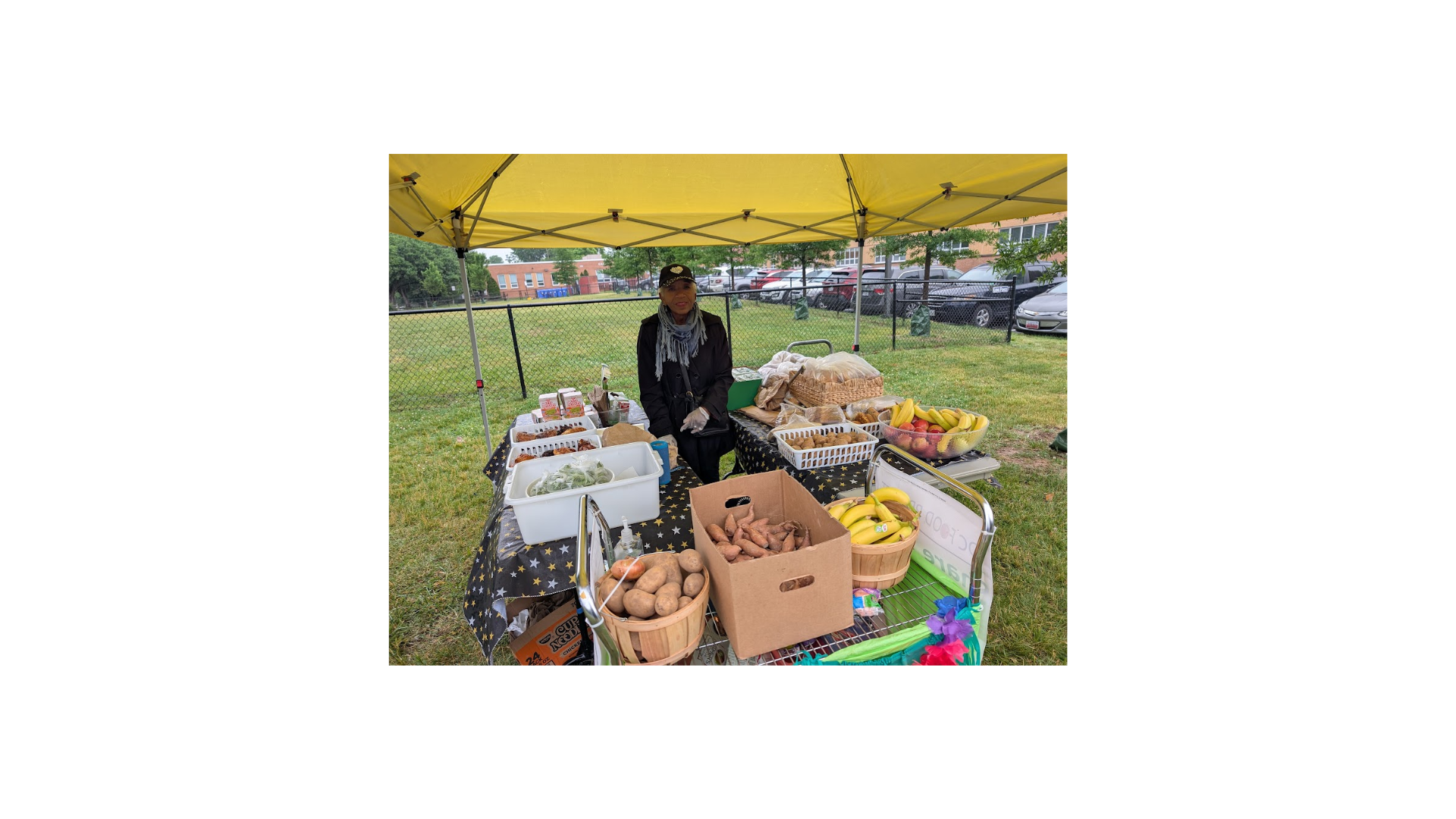 Monday share table at Hoffman-Boston; volunteers and students standing behind table filled with produces and treats.