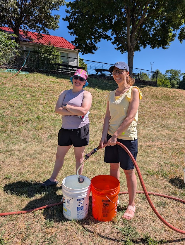 Parents helping with fielding; two parents filling bucket with water.
